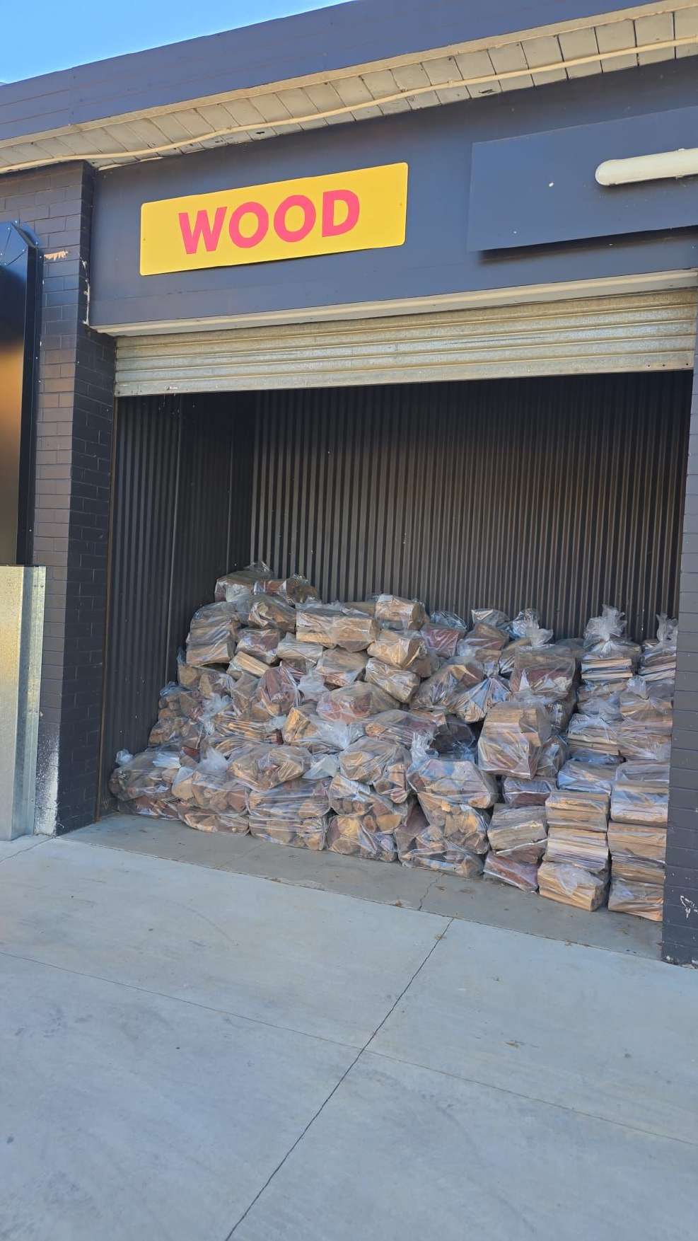 Firewood shed stocked with bags of wood
